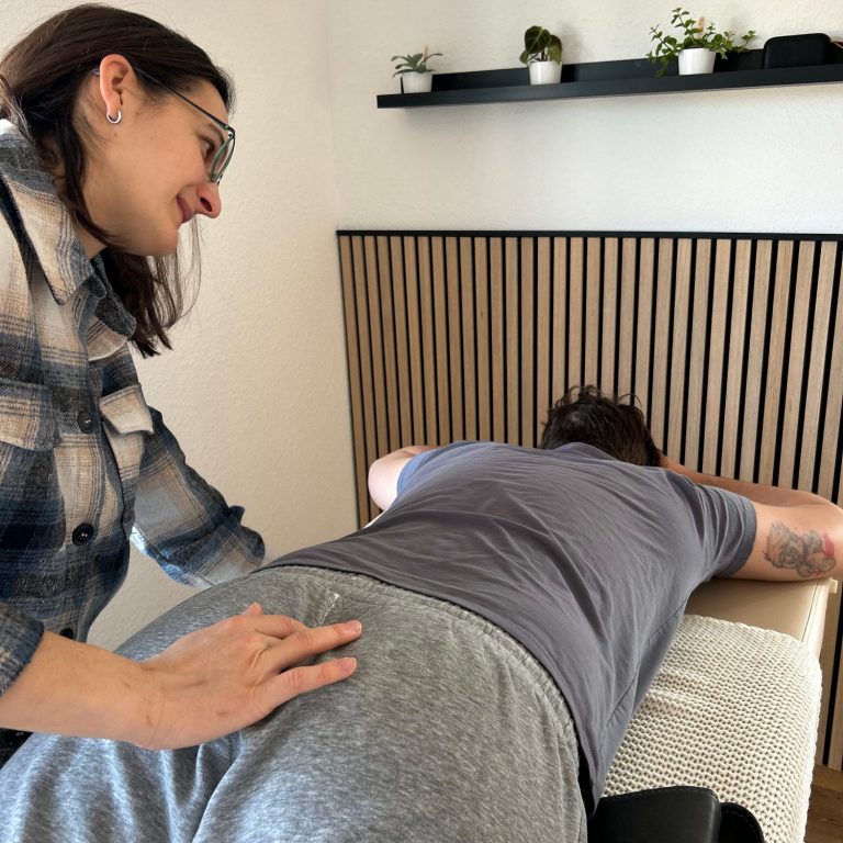 Franziska kontaktiert einen Punkt am Kreuzbein eines Klineten zur Unterstützung der Nervensystemregulation.