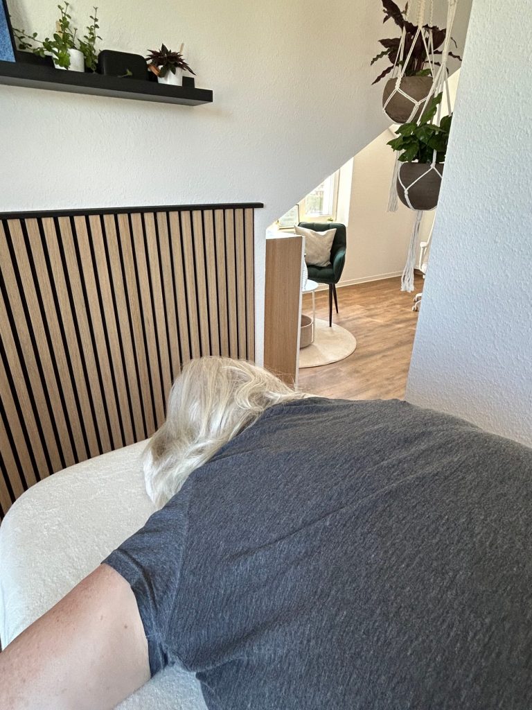 Sonjas Oberkörper und Kopf, welcher entspannt auf der Liege liegt. Sie geniesst eine Spinalflow Einheit in der ruhigen Spinalflow Idylle.
